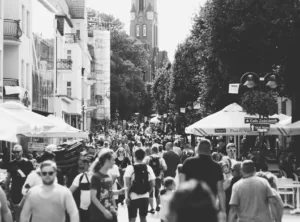 Imagem de uma rua muito movimentada com uma multidão a passear e a disfrutar do bom tempo em esplanadas.