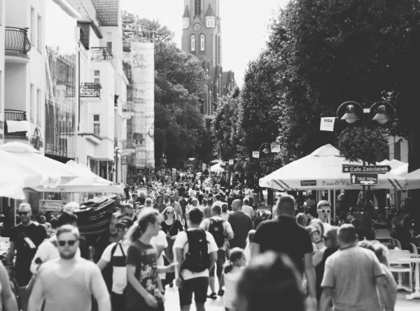Imagem de uma rua muito movimentada com uma multidão a passear e a disfrutar do bom tempo em esplanadas.